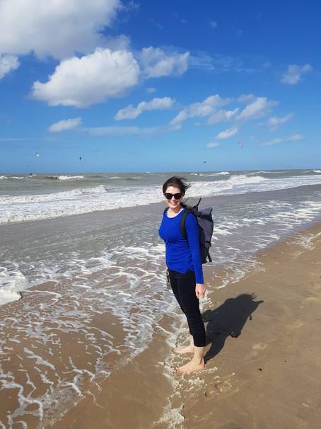 Here you see intern Polona spending a day at the beach in belgium. The weather is fine, but there is also a little wind. The waves in the sea are calm.