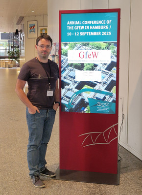 Dmitri Bershadskyy vor dem gfew Konferenzposter