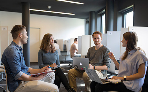 Vier Studierende sitzen im Kreis und reden miteinander