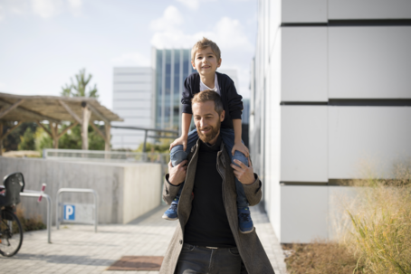Foto Mann trägt Kind auf Schultern