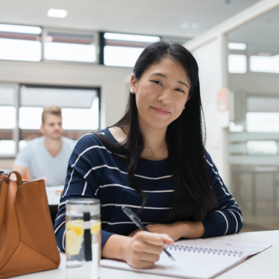 Female students is doing her work at the library.