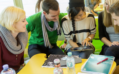 Studierende sehen sich auf einem Tablet gemeinsam etwas in der Lernzone im D3 Gebäude an.