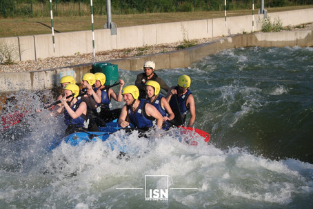 Group of young people in a rafting boat on a circuit.