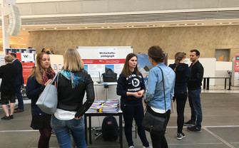 Studieninsteressierte stehen bei einem Infostand am Master day im Gebäude LC Forum