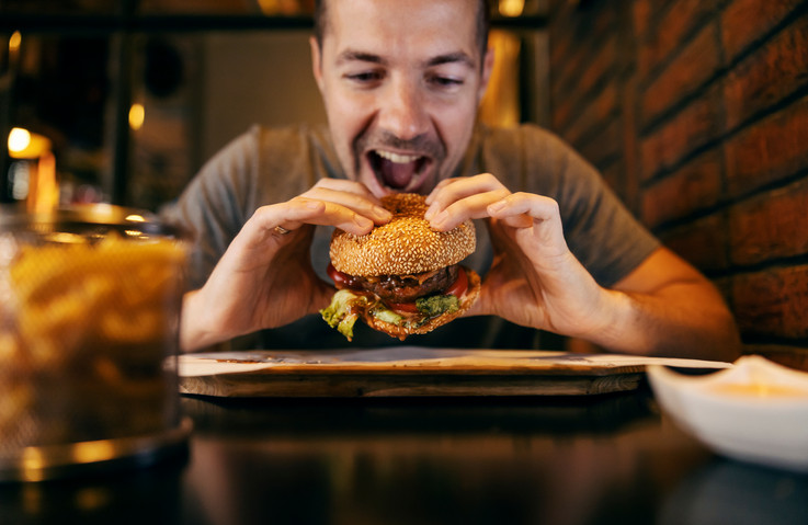 Ein Mann beißt in einen Burger