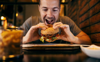 A man takes a bite out of a burger