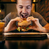 A man takes a bite out of a burger