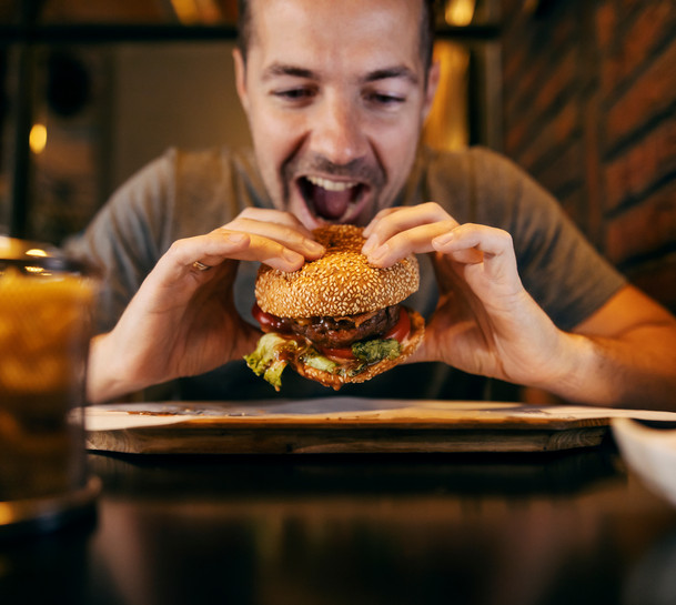 A man takes a bite out of a burger