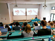 students in the auditorium, looking at woom's presentation