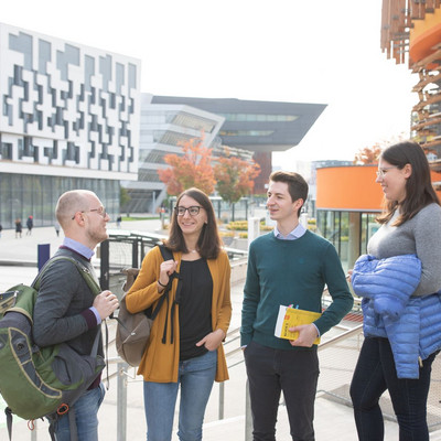 4 Studierende stehen vor dem Gebäude D3 und tauschen sich aus