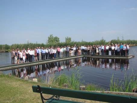 Many people standing on a pier on a lake