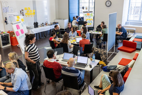 Das ExpLAB bietet den Rahmen für intensives Ausprobieren - die Teams sind in ihre Fragestellungen vertieft, werken an den Laptops und tauschen sich aus.