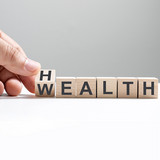 [Translate to English:] Würfel mit der Aufschrift Health/Wealth