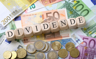 Das Wort Dividende auf einem Haufen Geld