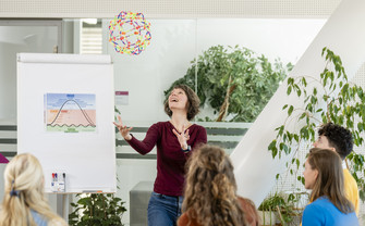 Bild Person wirft bunten Ball in die Luft