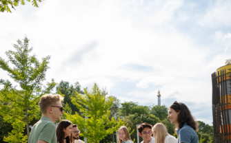 Studenten sitzen auf dem Gras am WU Campus