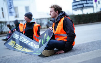 Klimaaktivisten auf der Straße klebend
