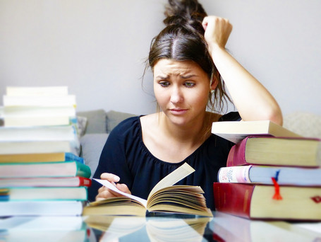 Student reading books with a desperate look on her face