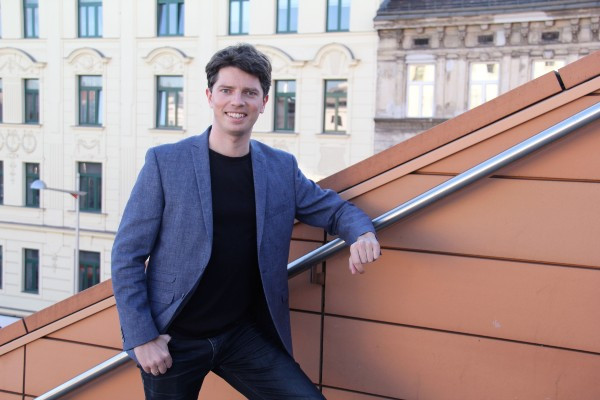 Portrait of a young man leaning on the roof top of a building. 