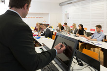 Ein Vortragender steht vor sitzenden Studierenden in einem Hörsaal