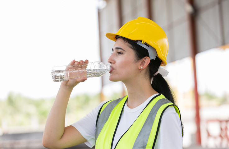 Bauarbeiterin trinkt Wasser