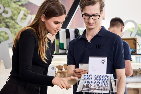 Ein Mann und eine Frau betrachten Ansichtskarten im WU Shop-
