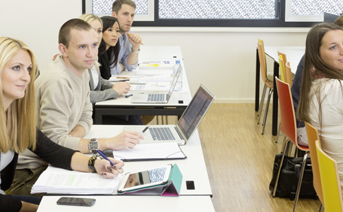 Studierende richten während eines Seminars den Blick zur Vortragenden. 