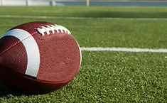 [Translate to English:] A football lying on a football field