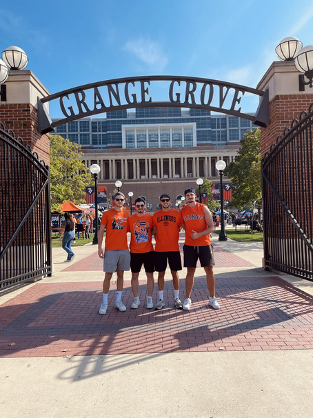 A group of students from illnois stand in front of a gate.