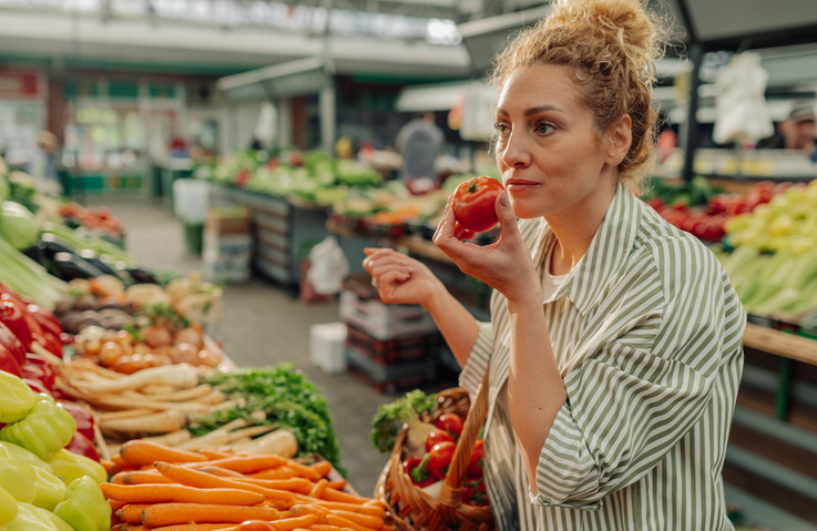 eine Frau riecht an einem Obst