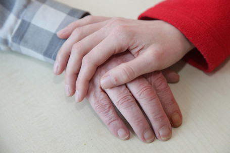 Hands of an employee and an elderly person