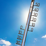 [Translate to English:] Foto eines Thermometers vor strahlend blauem Himmel
