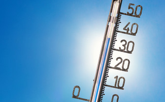 [Translate to English:] Foto eines Thermometers vor strahlend blauem Himmel