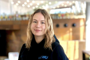 Portrait von Katharina Lautner, einer jungen Frau mit kinnlangen, brünetten Haaren, die in die Kamera lächelt