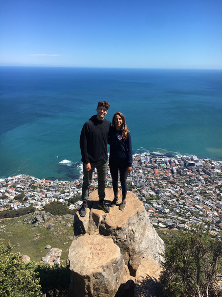 Two young People on top of a mountain in front of the sea.