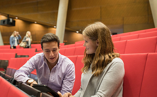 Zwei Studierende sitzen im Audimax