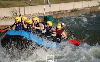 Group of students rafting in a boat.