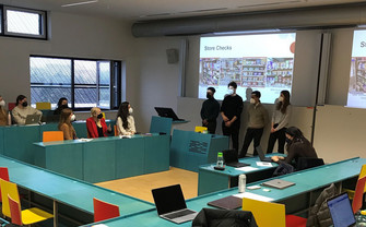 Photo showing four students presenting their findings in class