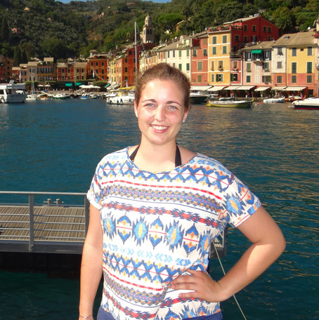 Young woman sits on a boat on the water in the background a place on the coast.