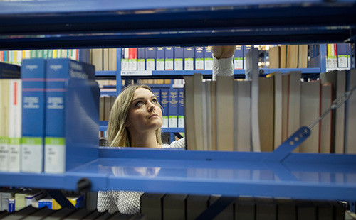 Eine Studierende sucht etwas in der Bibliothek