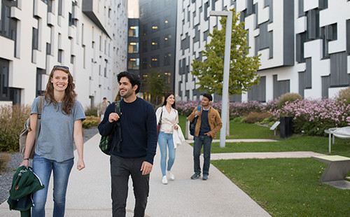 Studierende gehen zwischen den beiden D4 Gebäuden