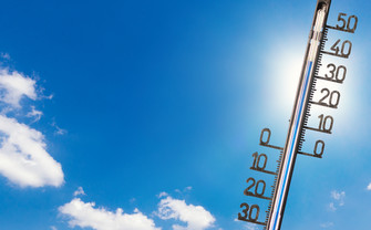 Foto eines Thermometers vor strahlend blauem Himmel