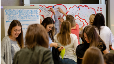 Group of students working on a presentation wall