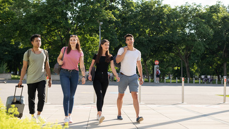 In this picture, you see a group of students walking on Campus WU. In the background, you can see trees of the Prater park.