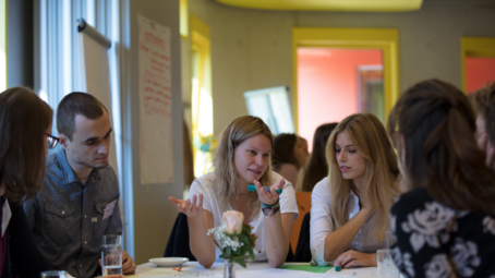 Group of students disussing at a table.