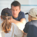 Ein Forscher spricht mit zwei Kindern