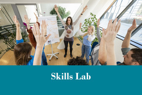 Foto Menschen stehen im Kreis und heben bei einer Übung im Skills Lab die Arme