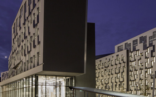 Blick auf das D4 Gebäude von außen bei Nacht. 