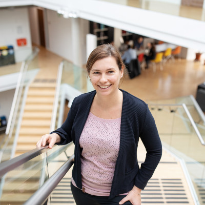 Andrea Haslinger, Programm Managerin, steht auf Stiegen und lächelt in die Kamera