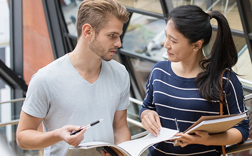 Zwei Studierende stehen im Stiegenhaus des Teaching Centers